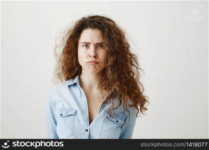 Portrait of displeased upset angry female, being discontent and unhappy, isolated over grey studio background. Portrait of displeased upset angry female, being discontent and unhappy, isolated over grey studio background.
