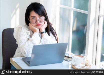 Portrait of displeased upset frustrated frowning asian female freelance people business female looking casual working with laptop computer with coffee cup and smartphone in coffee shop.