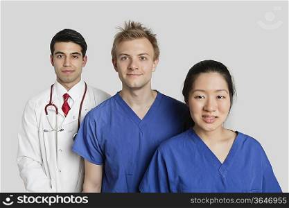 Portrait of diverse medical team standing over gray background