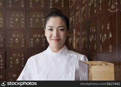 Portrait of Doctor In Front of Traditional Chinese Medicine Cabinet