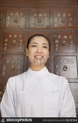 Portrait of Doctor In Front of Traditional Chinese Medicine Cabinet