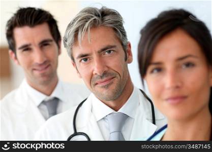 Portrait of doctor standing amongst medical team