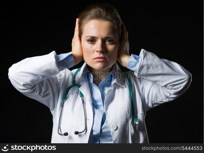 Portrait of doctor woman showing hear no evil gesture isolated on black