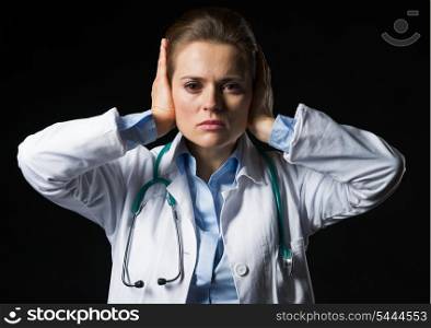 Portrait of doctor woman showing hear no evil gesture isolated on black