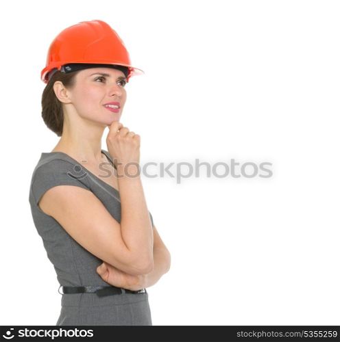 Portrait of dreaming architect woman in helmet looking on copyspace. HQ photo. Not oversharpened. Not oversaturated. Portrait of dreaming architect woman in helmet looking on copyspace isolated