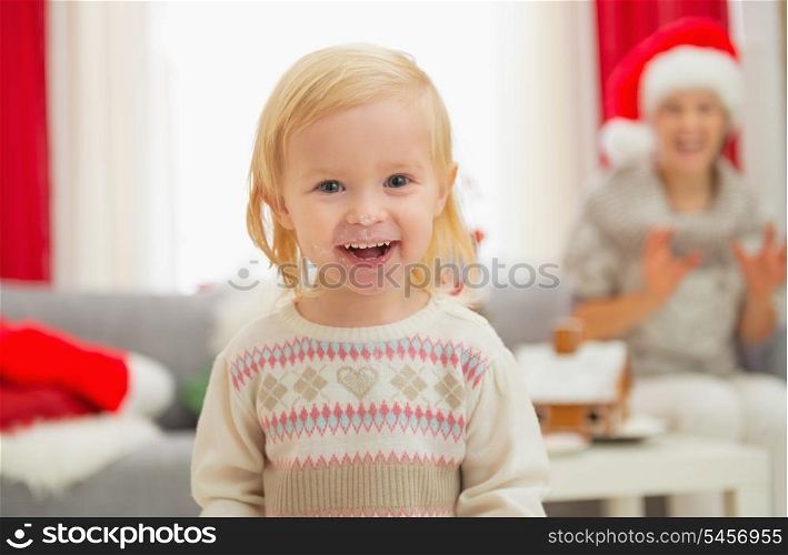 Portrait of eat smeared baby girl in Christmas enjoying Christmas