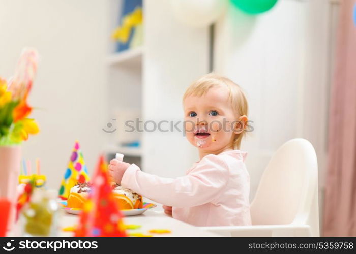 Portrait of eat smeared kid eating birthday cake