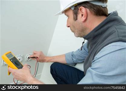 portrait of electrician installing wall socket