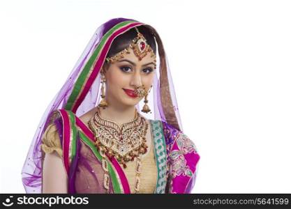 Portrait of elegant Indian bride against white background