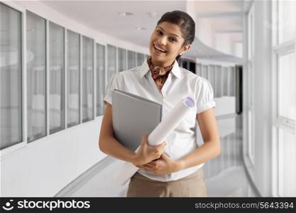 Portrait of elegant young businesswoman smiling with documents and paper