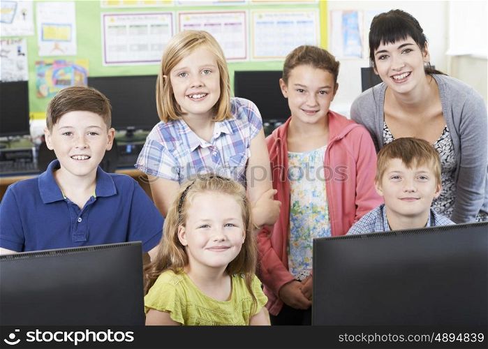 Portrait Of Elementary School Pupils With Teacher In Computer Class