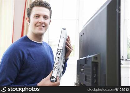 Portrait Of Engineer Installing Digital TV Equipment