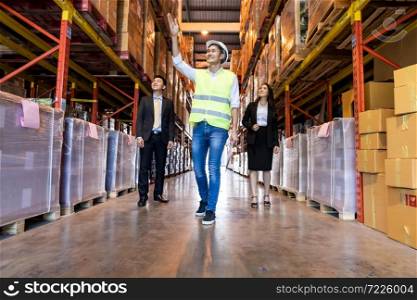 Portrait of engineer manager giving tour two businessman to inspect factory warehouse and discuss about warehouse inventory. Owner Investor Business deal and teamwork concept.