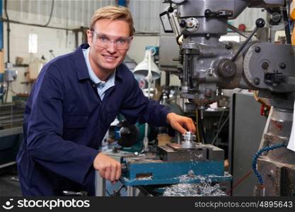 Portrait Of Engineer Using Drill In Factory