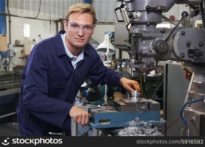 Portrait Of Engineer Using Drill In Factory
