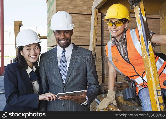 Portrait of engineers and female industrial worker smiling