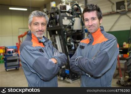 portrait of engineers folding arms in workshop