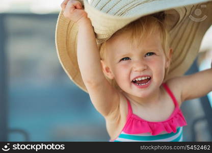 Portrait of excited baby in beach hat