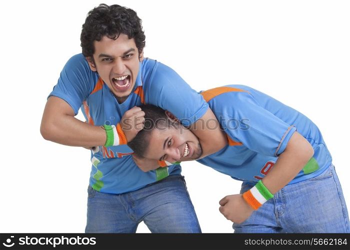 Portrait of excited young male friends in jerseys having fun over white background