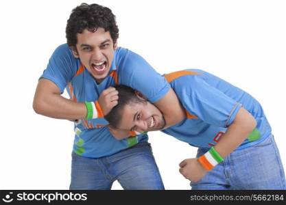 Portrait of excited young male friends in jerseys having fun over white background