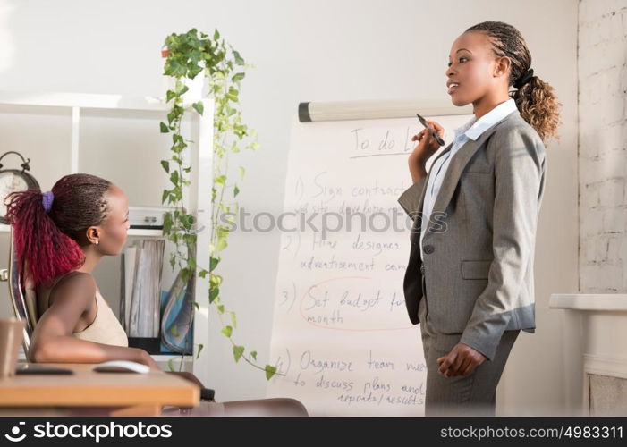 Portrait of executive businesswoman presenting her plan and idea to her colleague at meeting. Teamwork.