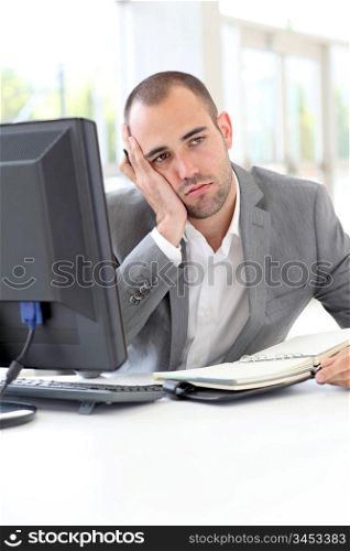 Portrait of exhausted businessman in office
