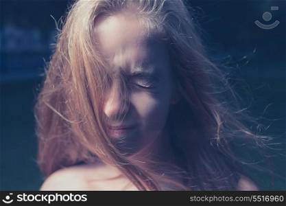Portrait of exited beautiful young woman on a dark nature background. Outddors shot in the evening time.