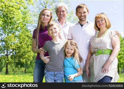 Portrait of extended family in park. Portrait of extended family with children and seniors in summer park