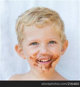 Portrait of fair-haired boy with chocolate on his face isolated on white background,baby boy smile,square photo.