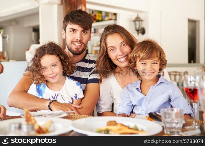 Portrait Of Family Enjoying Meal In Restaurant
