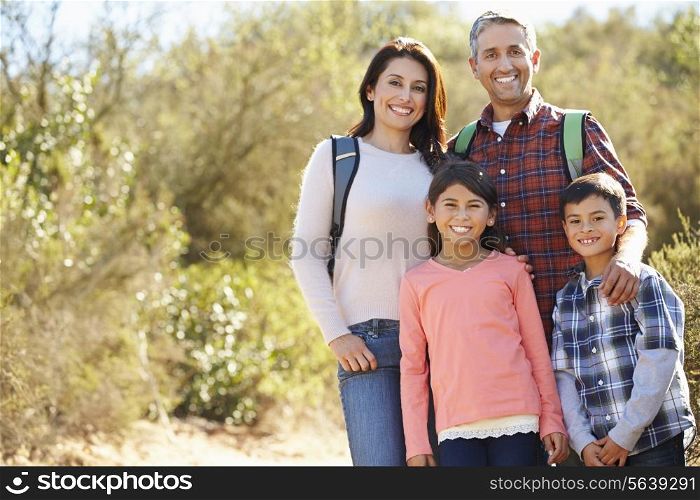 Portrait Of Family Hiking In Countryside Wearing Backpacks