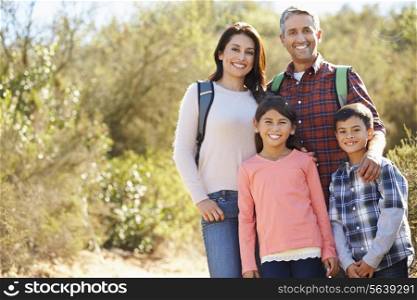 Portrait Of Family Hiking In Countryside Wearing Backpacks