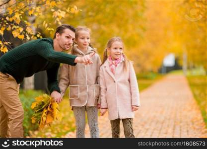 Portrait of family in autumn in the park. Dad and kids together outdoors. Family of dad and kids on beautiful autumn day in the park