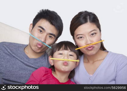 Portrait of family making a face with drinking straws