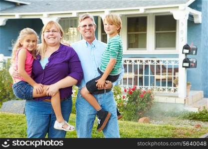 Portrait Of Family Outside Suburban House