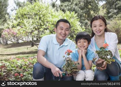 Portrait of family planting flowers.