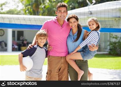 Portrait Of Family Playing Volleyball In Garden At Home