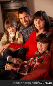 Portrait Of Family Relaxing On Sofa By Cosy Log Fire