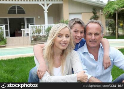 Portrait of family sitting in front of their house