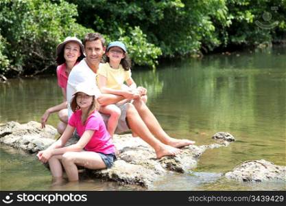 Portrait of family sitting in river in summer