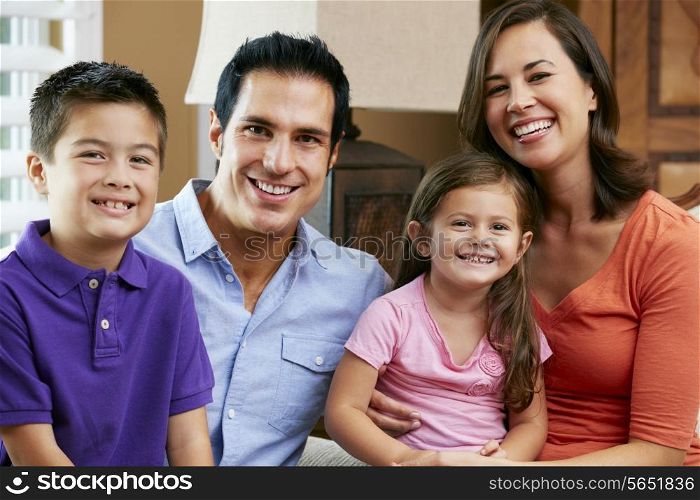 Portrait Of Family Sitting On Sofa At Home