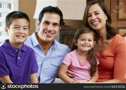 Portrait Of Family Sitting On Sofa At Home