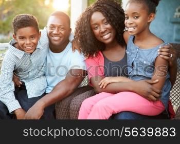 Portrait Of Family Sitting Outside House