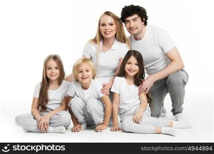 Portrait of family with children. Studio portrait of family in white clothes with three children isolated on white background