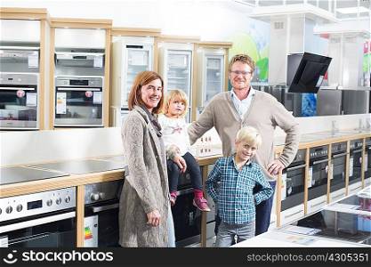 Portrait of family with two children browsing hobs in electronics store