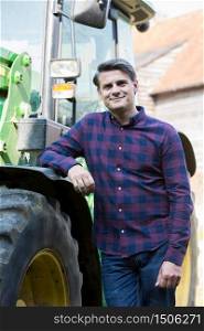 Portrait Of Farmer Standing Next To Tractor