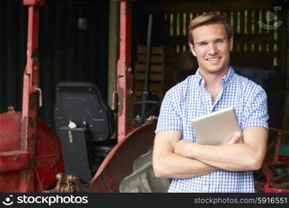 Portrait Of Farmer With Old Fashioned Tractor And Digital Tablet