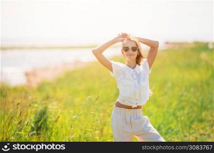 Portrait of fashion beautiful girl walking on the lake at suumer. Young beautiful girl having fun on the coast