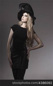 portrait of fashion Halloween woman with gothic style, leather skirt, witch hat and creative make-up