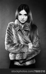 portrait of fashionable woman in fur coat dark background, monochrome shot